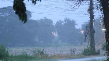 Heavy rain caused by the storm in the evening- as the cars were driving on the road made the traffic dangerous, requiring caution on rural roads in Thailand. video