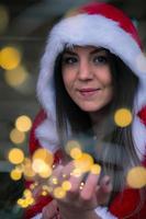 una mujer navideña con una cadena de luces en la mano foto