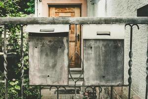 old mailboxes in front of a house entrance photo