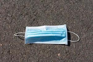 Close-up of a surgical mask thrown on the street photo