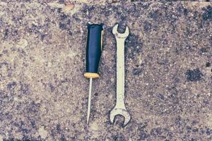 Wrench and hole punch tool on concrete photo