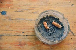 ashtray with old cigarettes on a rustic table photo