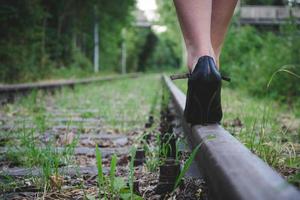 mujer con tacones altos en una vía férrea foto