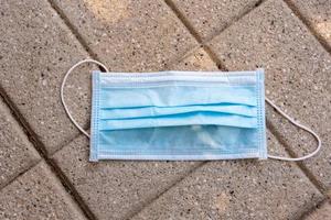 Close-up of a surgical mask thrown on the street photo