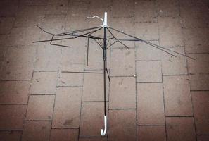 Metal white and black umbrella frame on the ground photo