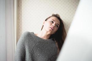 Attractive young woman sitting daydreaming photo