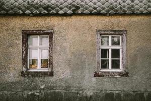 Old house grey facade with wooden windows photo
