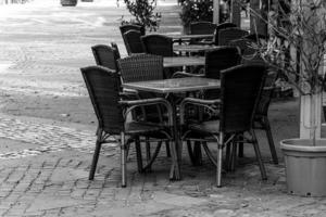 chairs and tables in front of a cafe in a city photo