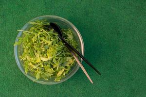 Bowl of fresh green arugula or rocket photo