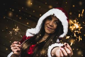 niña en traje de santa con bengalas foto