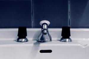 Old taps with central mixer on a hand basin photo