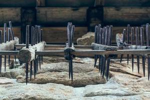 Iron pins and wooden logs over stone photo
