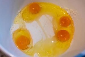 a bowl full of egg flour and sugar photo