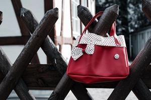 Colorful red handbag on a wooden fence photo