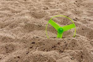 a green propeller on a sandy beach photo