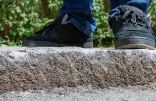 Feet of a person standing on exterior stone steps photo