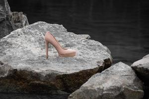 a single high heel on a rock photo