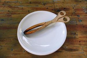 wooden barbecue tongs on a rustic wooden table photo