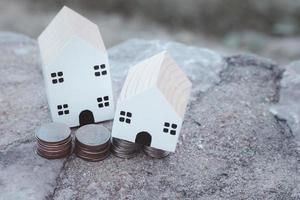 Wooden house on stacks of coins. Vintage style investment real estate ideas and free space for your messages. photo