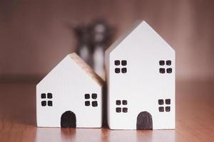 Two small white wooden houses on the table photo