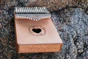 Hand playing kalimba or mbira is an African musical instrument.made from wooden board with metalInstrument in garden photo