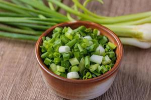 Sliced spring onions in a ceramic cup photo