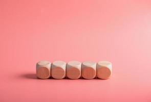 blank wooden dice for inserting text.on pink background photo