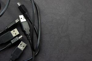 cierre los cables usb y mini usb sobre fondo negro con lugar para su diseño foto