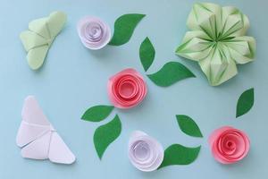 Origami paper background with butterflies, flowers and leaves. Origami composition. Paper craft photo