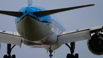 AMSTERDAM, THE NETHERLANDS JULY 27, 2017 - KLM Boeing 777 airliner landing on the runway in a crosswind with it's fuselage slightly skewed. View from the edge of the runway behind ALS masts video