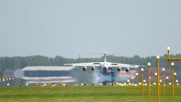tocar el tren de aterrizaje y humo al frenar. avión de pasajeros de cuatro motores aterrizando en el aeropuerto internacional de amsterdam. video