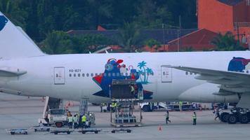 phuket, tailândia, 2 de dezembro de 2018 - azur air boeing 777 avião vq bzy sendo descarregado na chegada ao aeroporto internacional de phuket. video