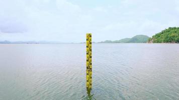 a escala amarela mede a altura da água na represa. a água no reservatório é abundante e é usada para a agricultura e o consumo da aldeia.reservando a natureza da água na tailândia video