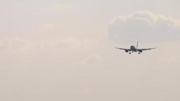 Verkehrsflugzeug im Endanflug vor der Landung auf dem Hintergrund des sonnenbeschienenen bewölkten Himmels. video