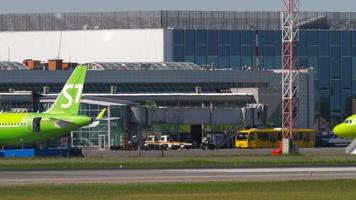 NOVOSIBIRSK, RUSSIAN FEDERATION JUNY 12, 2022 - Airplane of S7 Airlines taxiing to the terminal at airport Tolmachevo, Novosibirsk. View of the airport apron