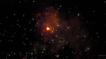prachtig veelkleurig feestelijk vuurwerk in de nachtelijke hemel boven de stad. vakantie concept. felle lichten ter ere van de vakantie video