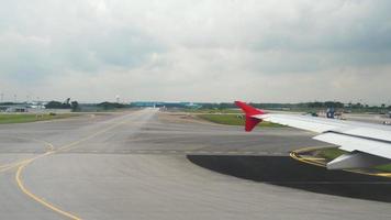 vista dall'oblò sull'ala dell'aereo passeggeri e dall'aerodromo dell'aeroporto di Singapore prima della partenza video