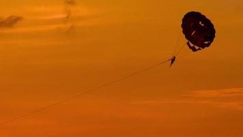 parachute ascensionnel sur la plage de karon au coucher du soleil, phuket, thaïlande video