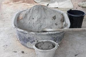 Cement and hoe in plastic bucket  for mixer in construction site. photo