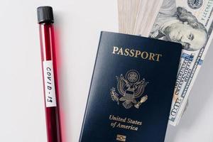 Coronavirus and travel concept. Blood samples, passport and money isolated on white background. Canceled flights because of world pandemic. Virus outbreak photo
