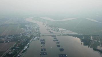 vue aérienne bateau de pêche naviguant dans un matin brumeux à kuala kurau. video