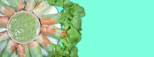 top view salad rolls in dish on the green background photo