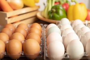 eggs of duck and chicken are placed on a wooden table with various vegetables photo