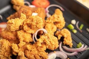 Chicken fried in a black pan photo