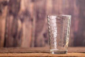 vaso de agua transparente vacío en la mesa de madera foto