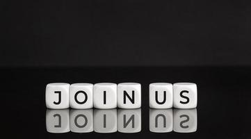 Join us phrase on white blocks on black background. Copy space photo