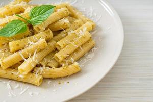 pesto rigatoni pasta with parmesan cheese photo