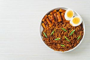 Jjajang Rabokki - Korean instant noodles or Ramyeon with Korean rice cake or Tteokbokki and egg in black bean sauce photo