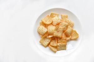 Delicious potato chips with pepper on a white plate photo