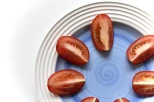 Sliced red tomato on a white plate photo